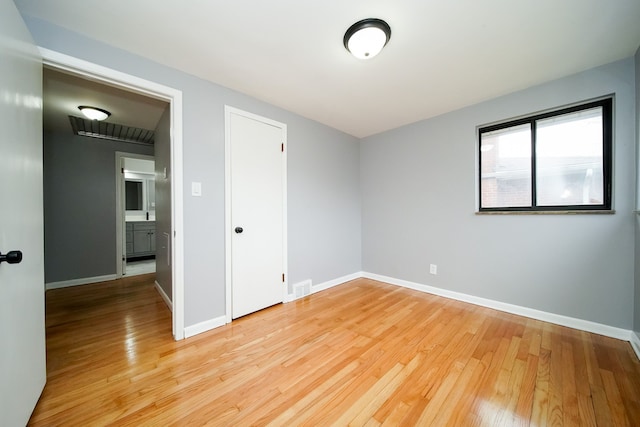 spare room featuring light wood-style flooring, baseboards, and visible vents