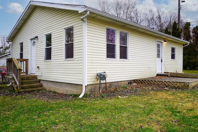 back of house with crawl space and a yard