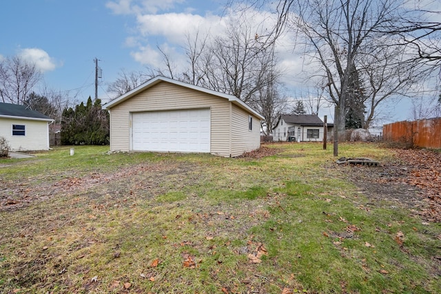 view of yard featuring an outdoor structure, fence, and a garage