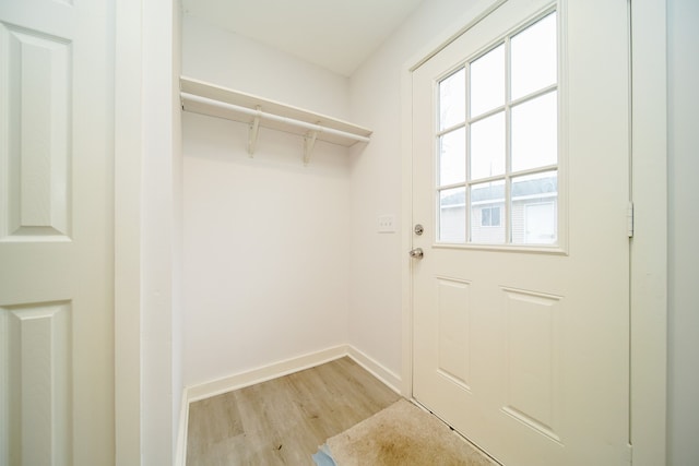 laundry area with baseboards and light wood-style floors