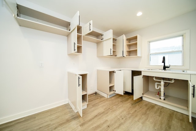 laundry area featuring a sink, baseboards, recessed lighting, and light wood finished floors