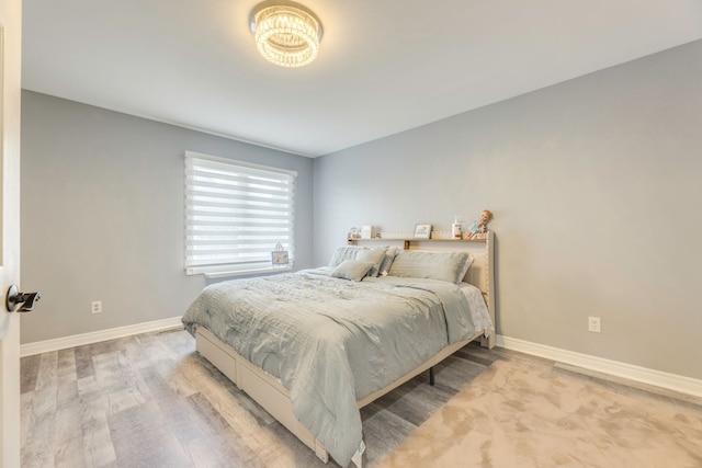 bedroom with light wood-style flooring and baseboards