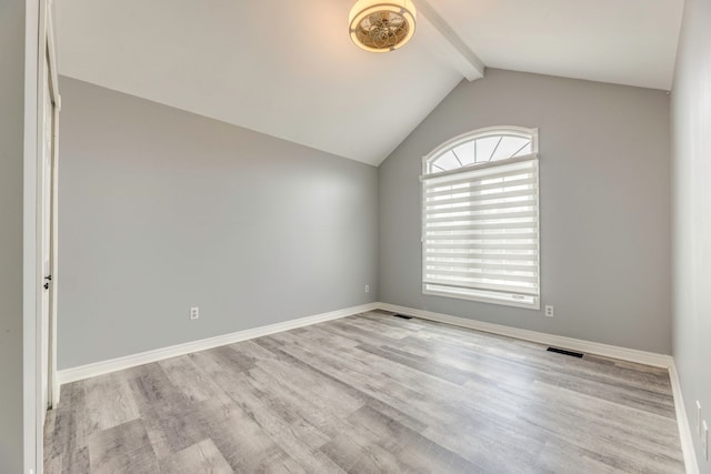 empty room featuring visible vents, vaulted ceiling with beams, baseboards, and wood finished floors