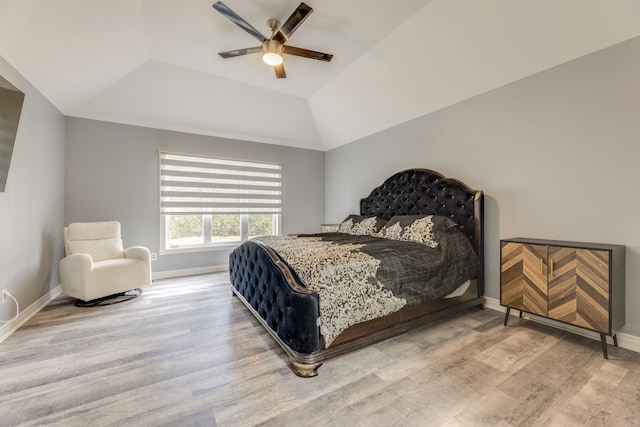 bedroom featuring vaulted ceiling, wood finished floors, baseboards, and ceiling fan