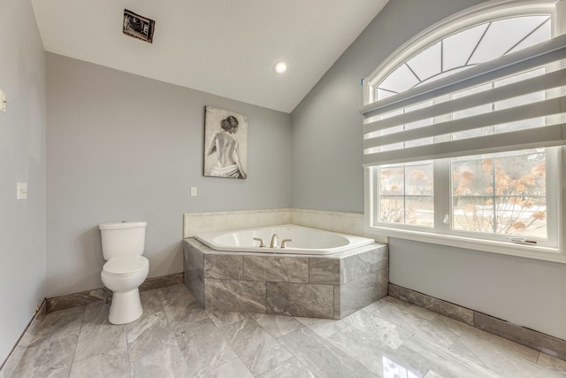 full bathroom featuring a bath, a healthy amount of sunlight, toilet, and vaulted ceiling