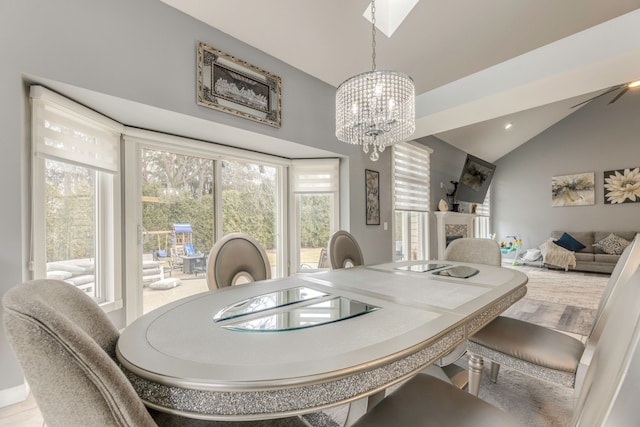 dining area featuring vaulted ceiling, a notable chandelier, a fireplace, and recessed lighting