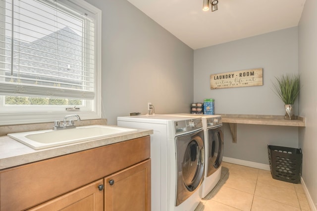 laundry room featuring baseboards, washer and clothes dryer, light tile patterned floors, cabinet space, and a sink