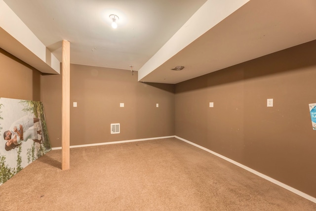 finished below grade area with visible vents, baseboards, and carpet flooring