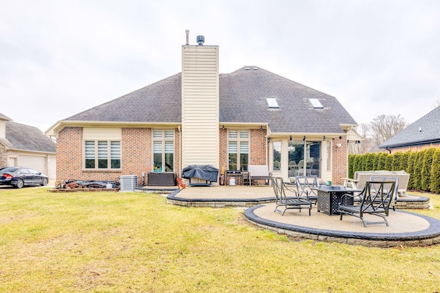 rear view of house featuring a patio, a yard, roof with shingles, brick siding, and a chimney