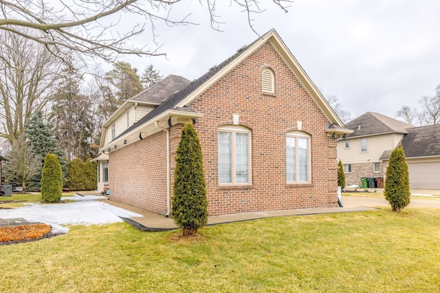 view of home's exterior featuring brick siding and a yard