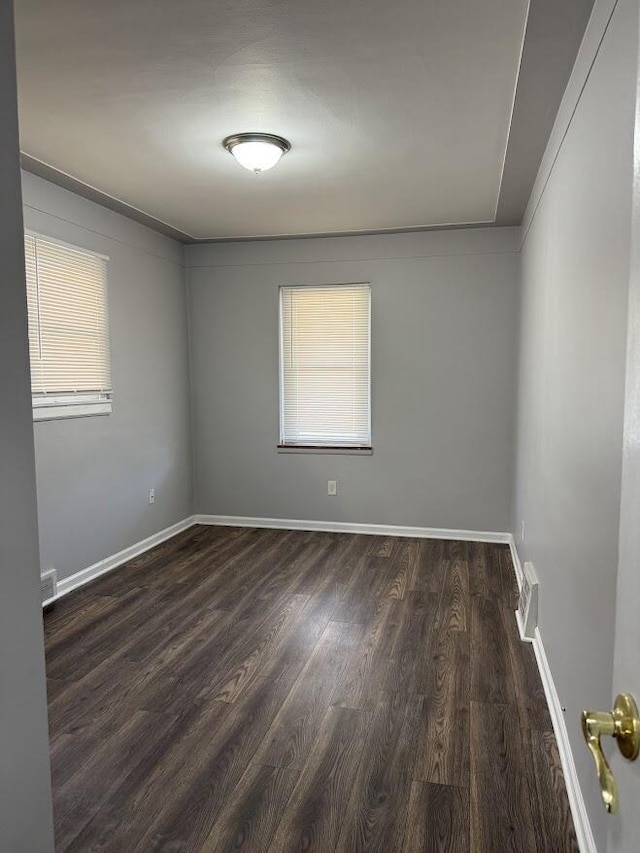 spare room with visible vents, baseboards, a healthy amount of sunlight, and wood finished floors