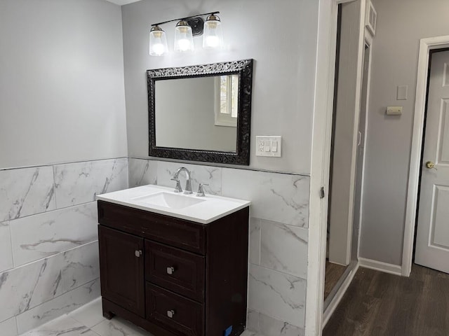 bathroom with vanity, tile walls, and wainscoting