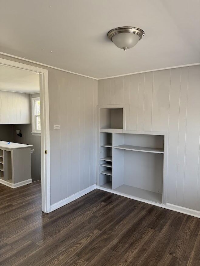 unfurnished bedroom featuring baseboards and dark wood finished floors