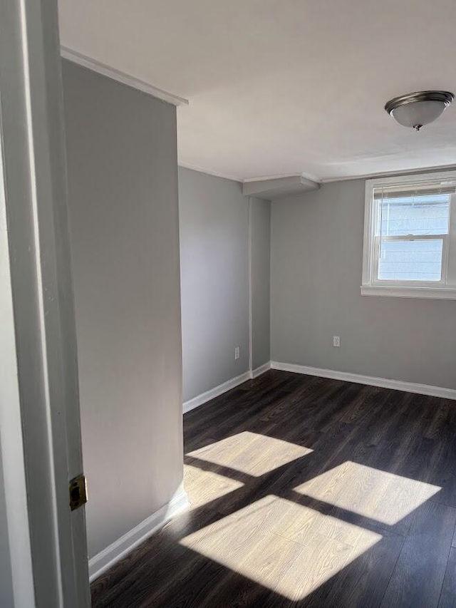 spare room with dark wood-style floors and baseboards