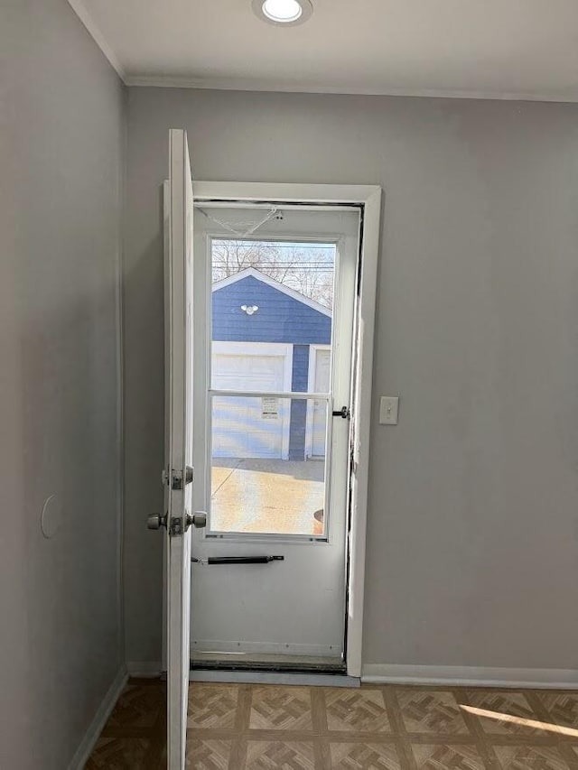 doorway to outside with crown molding and baseboards