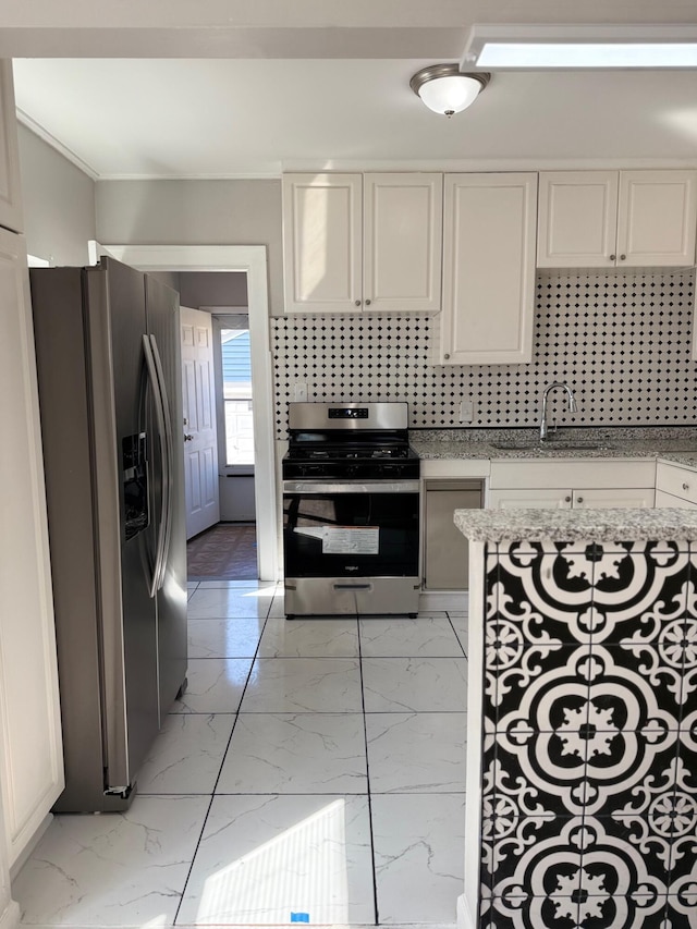 kitchen with tasteful backsplash, white cabinets, marble finish floor, stainless steel appliances, and a sink