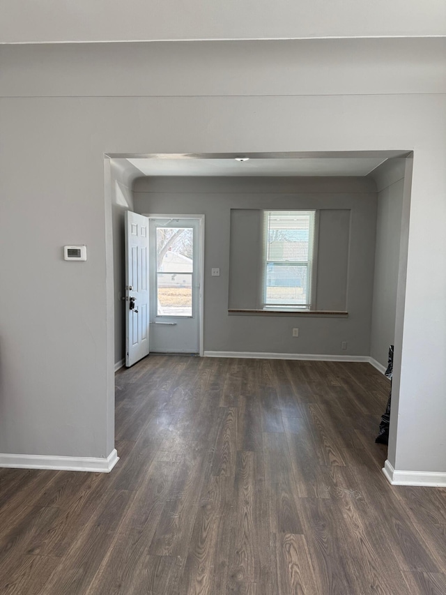 interior space featuring baseboards and dark wood-style flooring