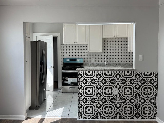 kitchen featuring white cabinetry, marble finish floor, appliances with stainless steel finishes, and a sink