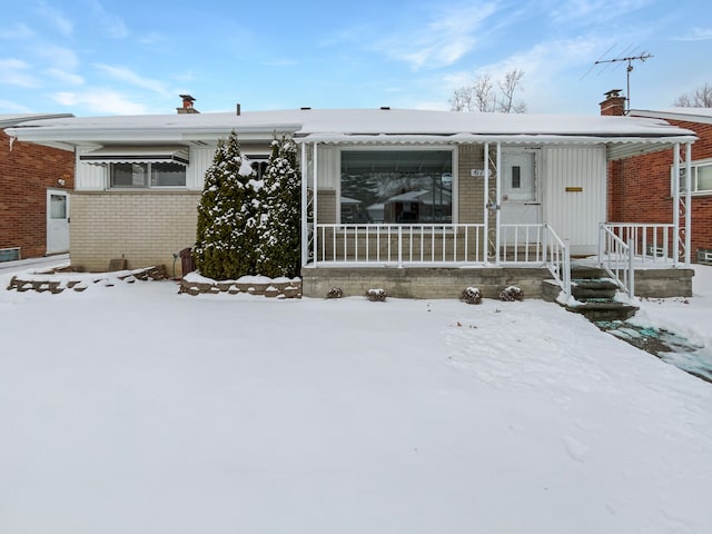 view of front of house featuring brick siding and a porch