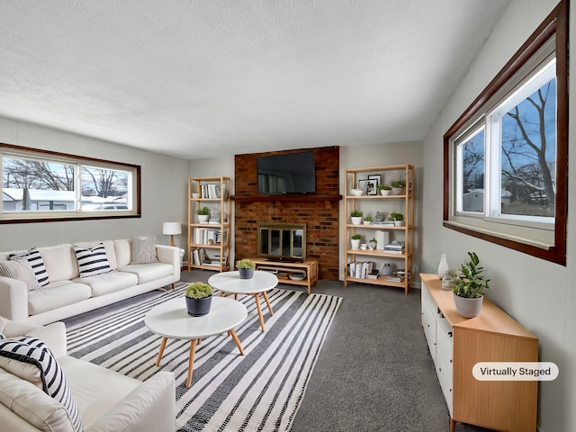 living area featuring a brick fireplace, carpet floors, and a textured ceiling