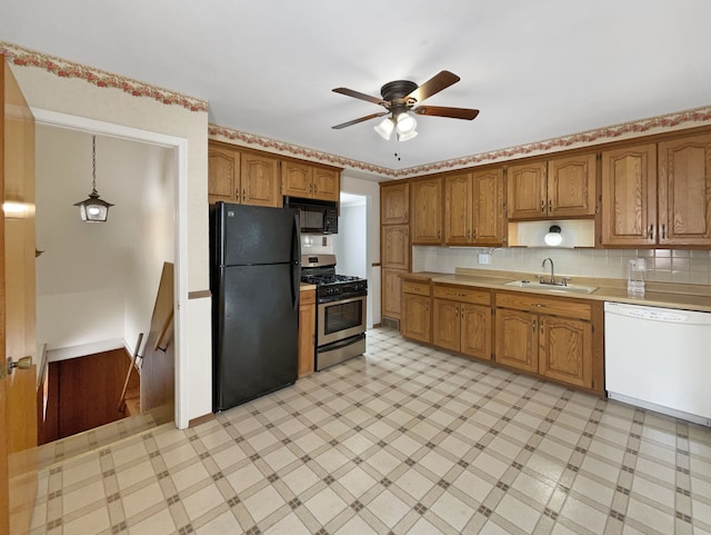 kitchen with brown cabinets, black appliances, a sink, light countertops, and light floors