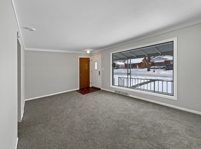 unfurnished room with visible vents, dark carpet, baseboards, and ornamental molding