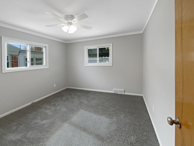 carpeted spare room with visible vents, baseboards, plenty of natural light, and ornamental molding