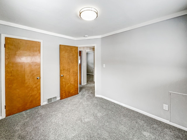 unfurnished bedroom featuring carpet, visible vents, and baseboards