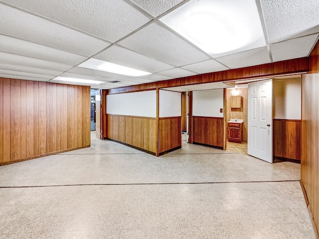 spare room featuring wooden walls, wainscoting, and a paneled ceiling