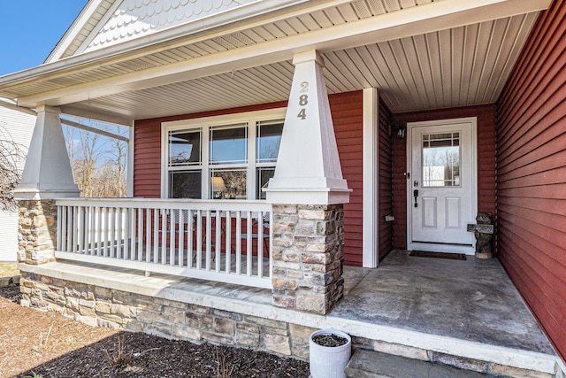 property entrance with stone siding and a porch