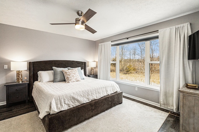 bedroom with ceiling fan, baseboards, and wood finished floors