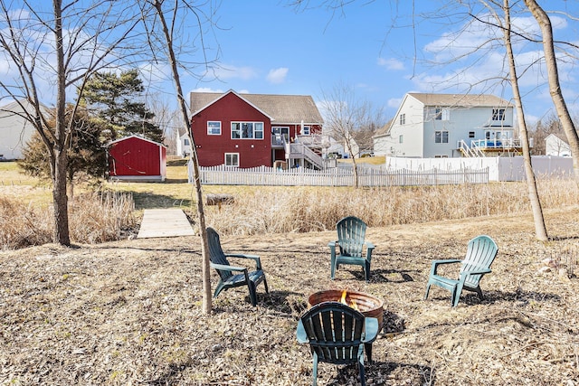 view of yard featuring fence, a shed, stairway, an outdoor fire pit, and an outdoor structure