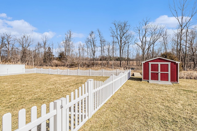 view of yard with an outbuilding, a storage unit, and a fenced backyard