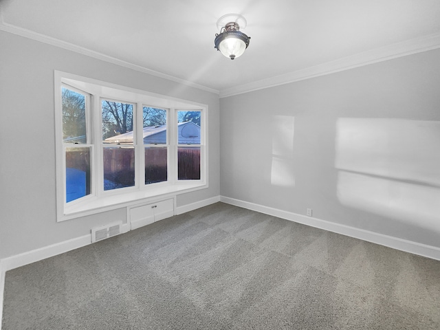 empty room featuring dark colored carpet, visible vents, baseboards, and ornamental molding