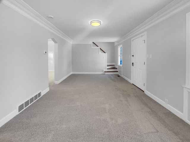 carpeted foyer with baseboards, visible vents, arched walkways, ornamental molding, and stairs