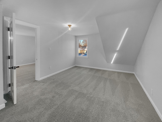 bonus room with baseboards and carpet