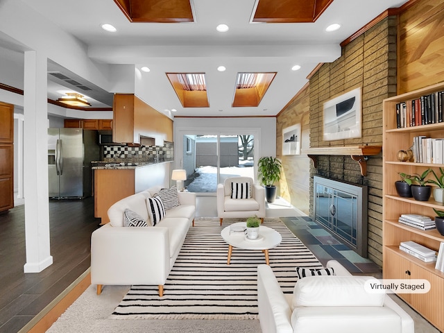 living room with recessed lighting, a brick fireplace, and vaulted ceiling with beams