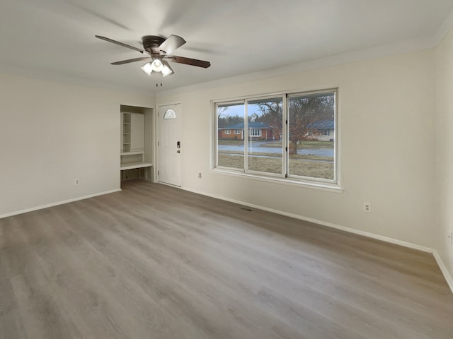 interior space with ceiling fan, visible vents, baseboards, and wood finished floors