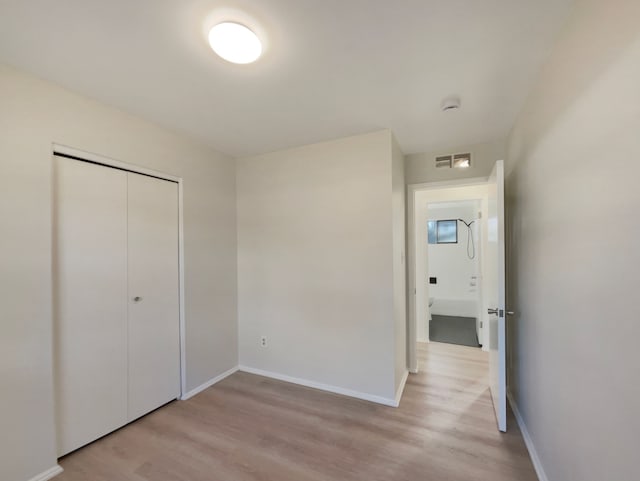 unfurnished bedroom with visible vents, baseboards, light wood-style floors, and a closet