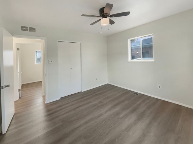 unfurnished bedroom featuring visible vents, baseboards, and dark wood finished floors