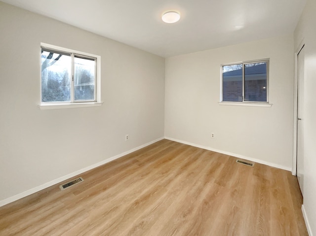 empty room featuring visible vents, baseboards, and light wood-style floors