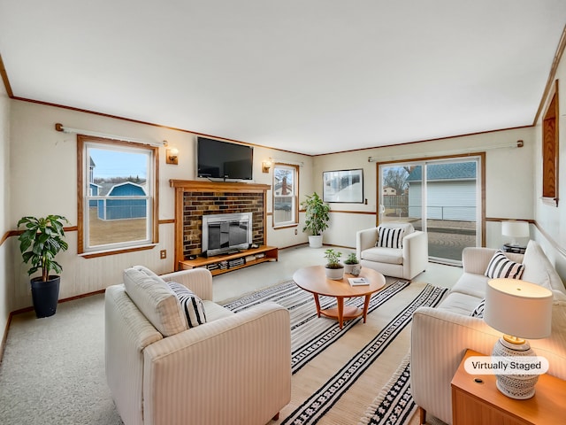 living room featuring carpet flooring, a healthy amount of sunlight, a brick fireplace, and crown molding