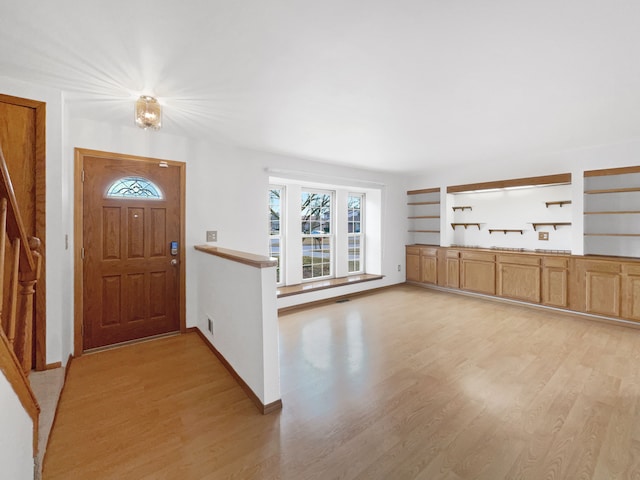 foyer entrance featuring visible vents, light wood-type flooring, and baseboards