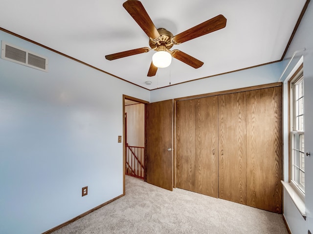 unfurnished bedroom with visible vents, carpet floors, baseboards, and ornamental molding