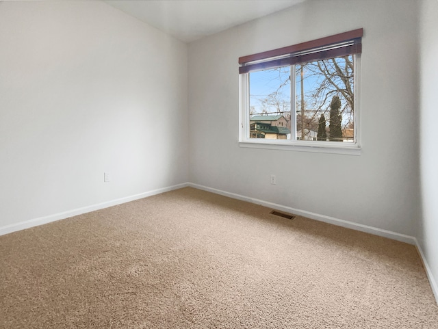 spare room featuring visible vents, baseboards, and carpet flooring