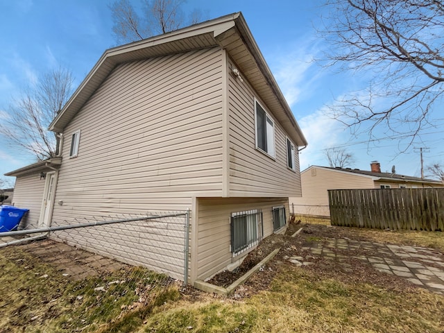 view of side of home featuring fence