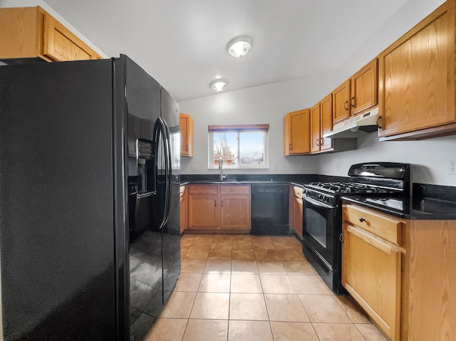 kitchen featuring light tile patterned floors, a sink, black appliances, under cabinet range hood, and dark countertops