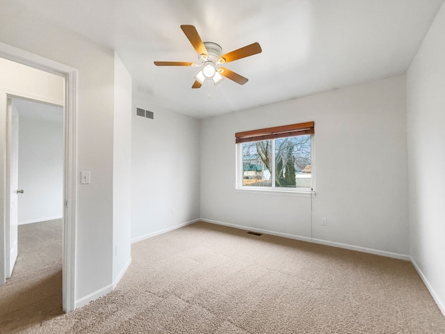 empty room featuring visible vents, a ceiling fan, baseboards, and carpet floors