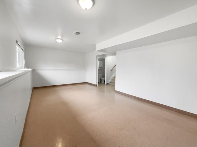 unfurnished room featuring visible vents, light floors, stairs, and baseboards