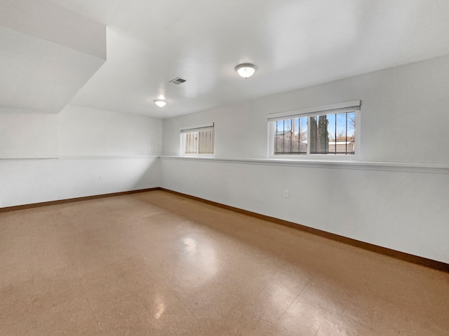 spare room with tile patterned floors, visible vents, and baseboards